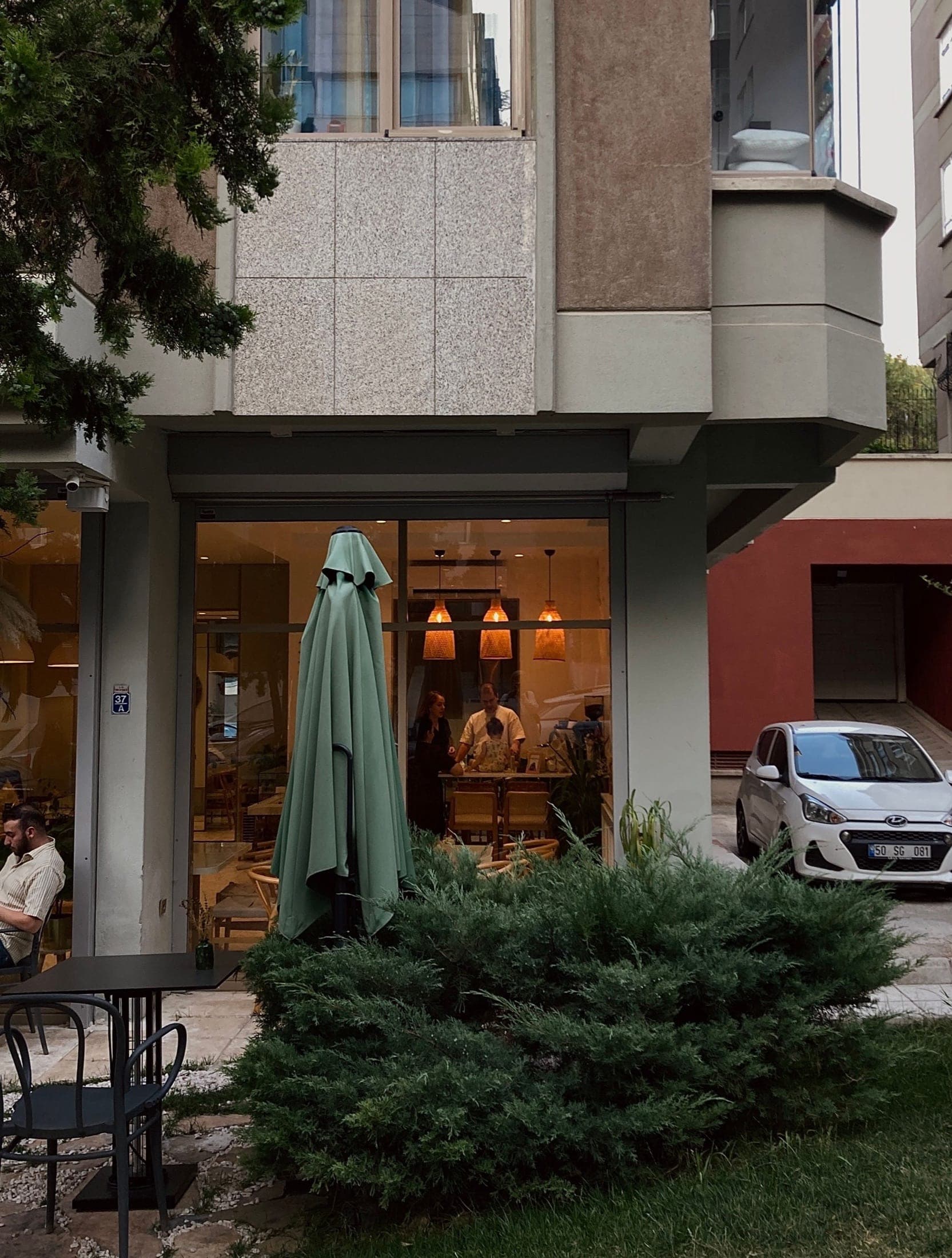 Fachada urbana de restaurante com mesas externas